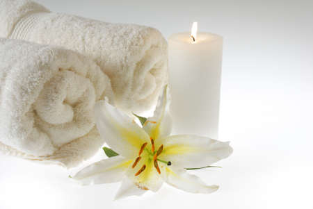 Dreamy scene of fluffy towles, a candle and a fragrant lily.の写真素材