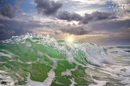 big ocean wave against a sunsetの写真素材