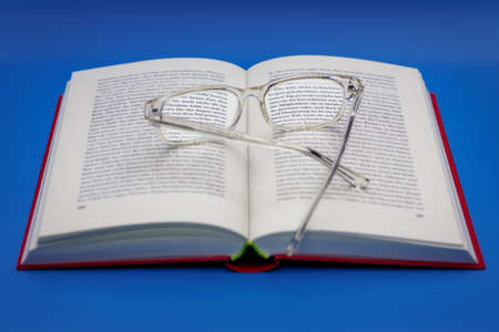 reading glasses on an open bookの写真素材