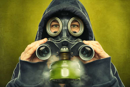 gas masked person is using a spyglassの写真素材