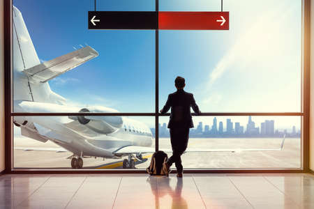 passenger at the airport is looking at an airplaneの写真素材