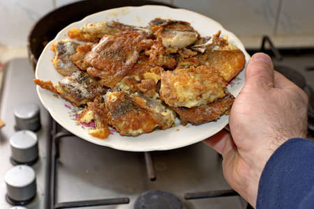 Fish roasting on frying pan at home kitchen