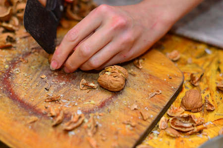 Whole walnuts in a bowl closeup. Whole walnuts, halves of nuts and walnut leaves.