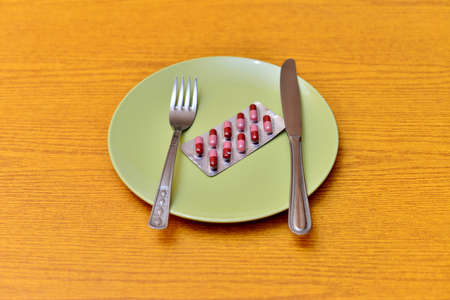 Medical dinner set with silverware and pillsの写真素材