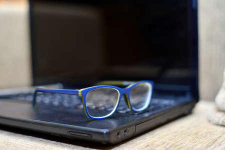 Eye Glasses on Businessman Wooden Table with Other Stuffs - Keyboard, Notebook, Pen and Phone.Office...