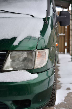 Close up of snow and ice covered back of a bright green carの写真素材