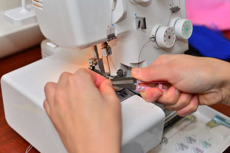 Portrait of a beautiful seamstress carrying a tape measure and working in a textile factory