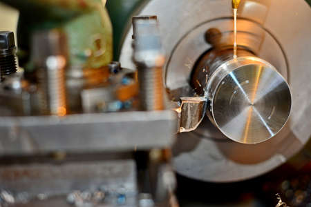 Professional machinist. Horizontal shot of a man operating lathe grinding machine metalworking...