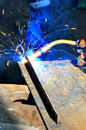 Industrial Worker labourer at the factory welding steel structure