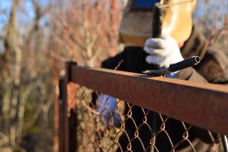 welder makes a fence in the street. Electric welder makes the fence in his own manorの写真素材