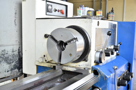 Professional machinist. Horizontal shot of a man operating lathe grinding machine metalworking...