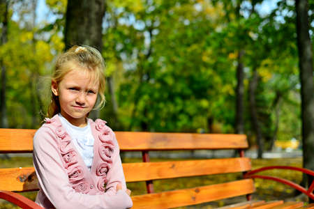Girl sitting in a bench in the parkの写真素材