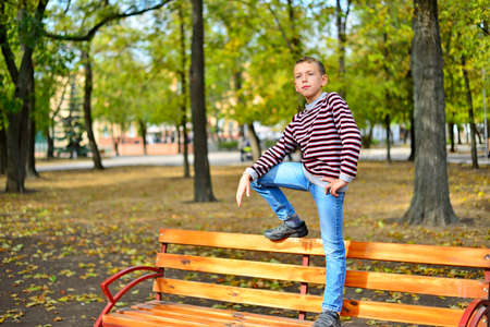 The young guy sits on a bench in parkの写真素材