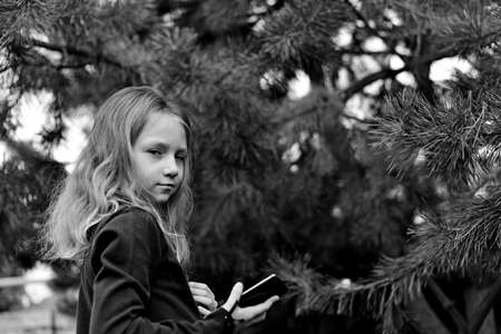 girl in headphones with phone in the forest with her hair downの写真素材