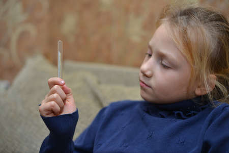 Close-up thermometer measuring temperature with pills on the backgroundの写真素材