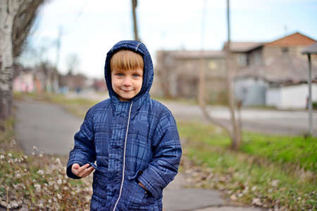Fashion portrait of a cute little blond boy, wearing black roll neck and blue jacketの写真素材