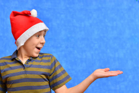Cute little boy in Santa hat on color backgroundの写真素材