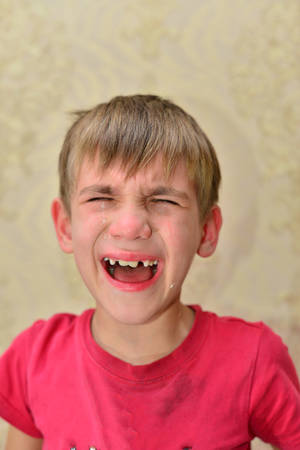 the boy in the red T-shirt is crying with tears