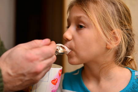 Little girl eating chocolate cream.Kid eating nut chocolate cream.の写真素材