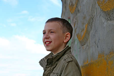 A boy in a jacket near the sea on the beach.の写真素材
