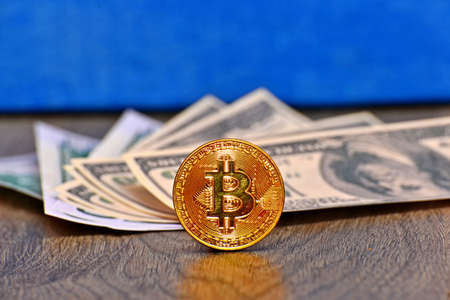 Gold coin bitcoin against the background of money dollars, close-up. Extraction of crypto currency.の写真素材