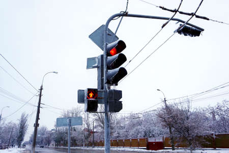 Traffic light on the street with ice and snow in the winter. Frozen road signs.の写真素材