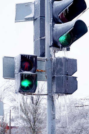 Traffic light on the street with ice and snow in the winter. Frozen road signs.の写真素材