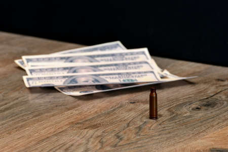 A shell from an automaton personifying war lies on the background of dollarsの写真素材