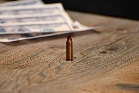 A shell from an automaton personifying war lies on the background of dollarsの写真素材