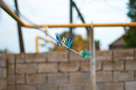 A blue clothespin hanging on the clotheslineの写真素材