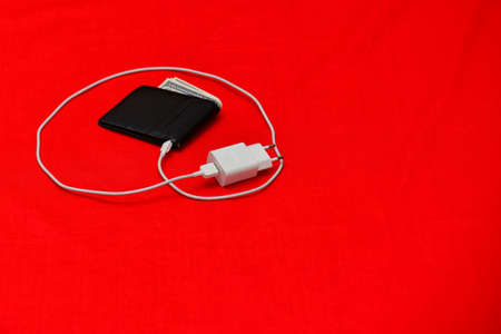 Black purse charged from the network on a red backgroundの写真素材