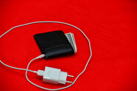 Black purse charged from the network on a red backgroundの写真素材