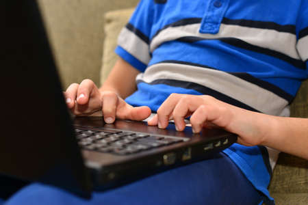 Smart Young Boy Works on a Laptop For His New Project in His Computer Science Class.の写真素材