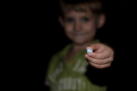 young boy hand showing diceの写真素材