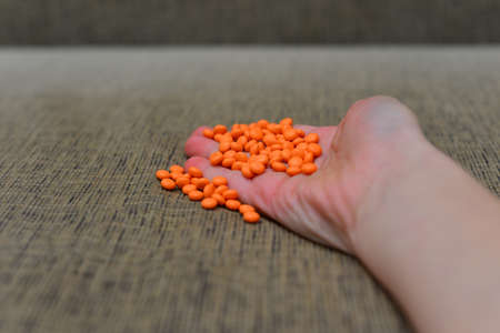 Different colored medications and tablets on a wooden texture tableの写真素材