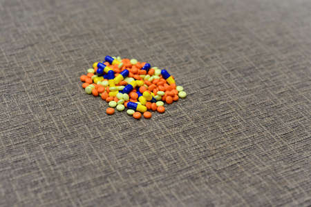 Different colored medications and tablets on a wooden texture tableの写真素材