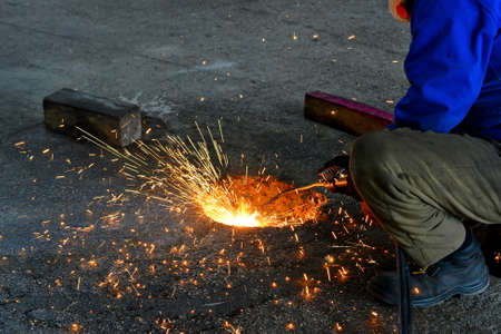 Industrial Worker. Welder-carver at the production of gas-welding with sparks.
