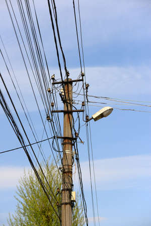The post is electric with wires and lamps on the street for illuminating in the dark.