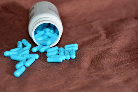 Blue medications are scattered from the cans for the treatment of diseases, the concept of health.の写真素材