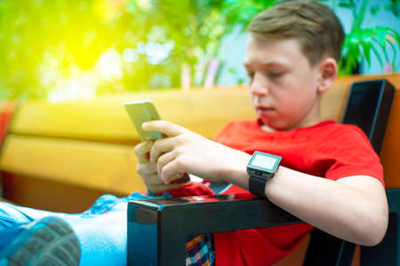 Boy with a smartphone on the bench