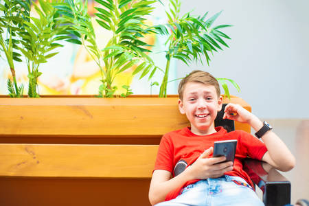 Boy with a smartphone on the bench