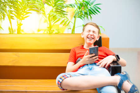 Boy with a smartphone on the bench