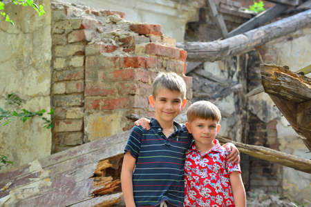 lLittle orphans were left without housing and stand near the ruins of the building as a result of a military conflict, a fire and an earthquake. Photo production.の写真素材