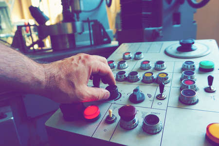 The worker uses the control panel of the CNC machine to process the material.の写真素材