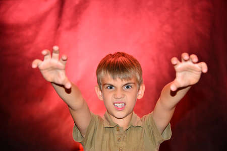 Portrait of an angry boy with a red-blue backlight.の写真素材