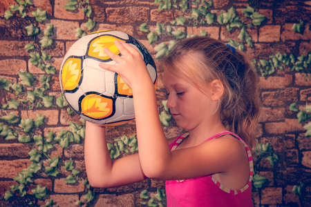 The girl is holding a soccer ball.の写真素材