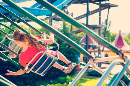 The girl is riding a carousel at high speed on a swing.の写真素材