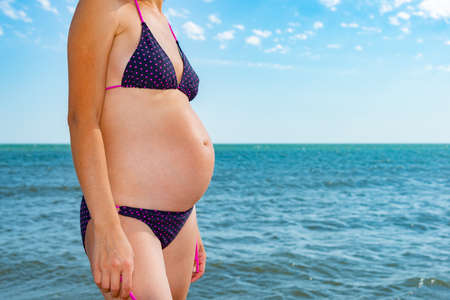 A pregnant woman on the sea and breathes the air and enjoys the peace.の写真素材