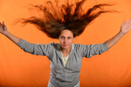 Beautiful and young girl throws up hair and holds hands in sides, concept of freedom and...