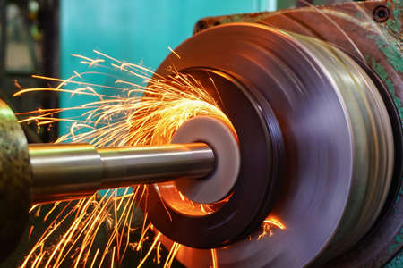 Production of parts in the metalworking industry, finishing on an internal steel surface grinding machine with flying sparksの写真素材